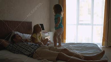 Two little sisters jumping on the bed and having fun
