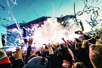 Silhouettes of concert crowd in front of bright stage lights