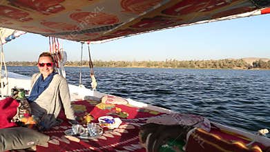 Nubian man and female tourist sailing with felucca on the Nile river