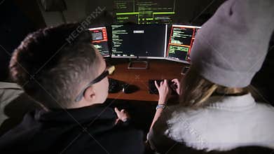 Young multiethnic computer hackers team hacking, trying to gain access to a computer system.