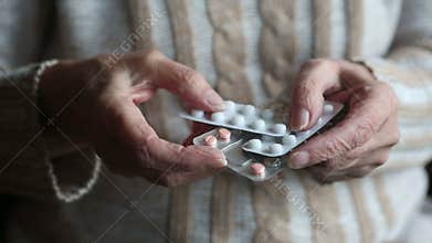 Closeup of old woman holding packages of medication