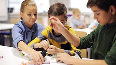 Happy children making high five at robotics school